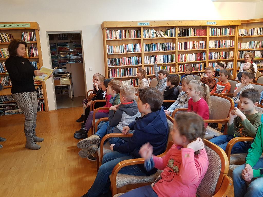 Lesung in der Bücherei: Autorin steht vor sitzenden Kindern